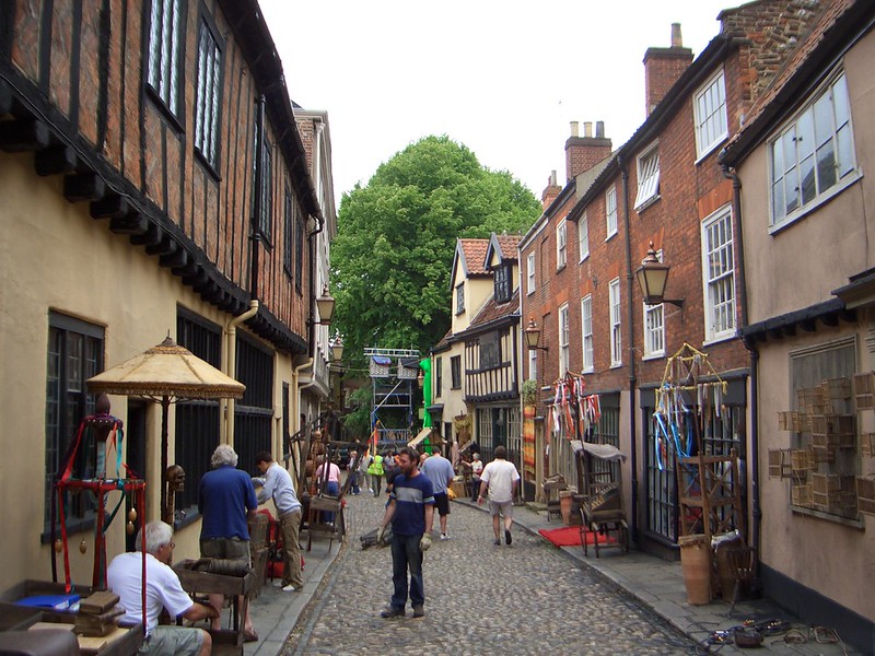 People on Elm Hill cobbled street in Norwich Norfolk, the historic Tudor lane used as a film location